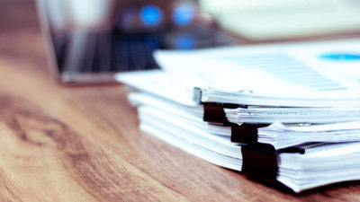 Stack of documents placed on a business desk in a business offic